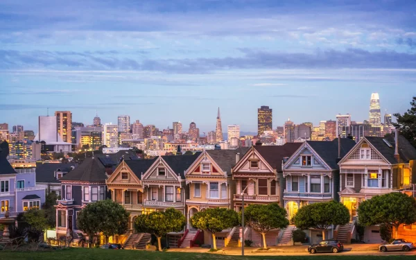 Painted Ladies in San Francisco at dusk The row of traditional Victorian style townhouses in San Francisco, known as the Painted Ladies, photographed in the blue hour after sunset, with the lights of the city on the horizon.